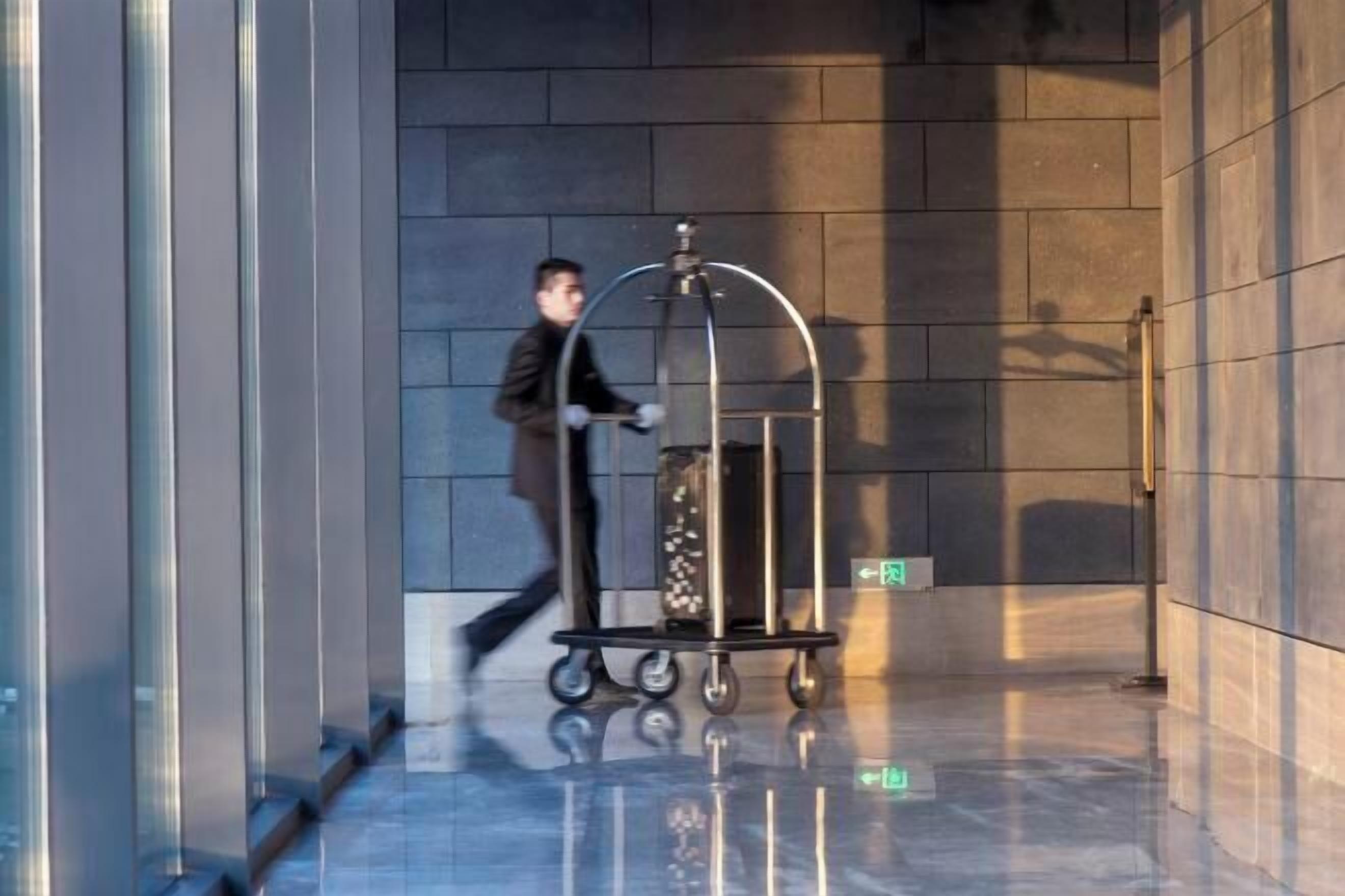 A modern elevator with a metallic cart and a glass container.