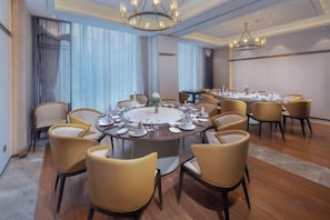 A conference room with a round table, chairs, and a chandelier. - Wuhu Maison New Century Hotel (Wuhu)