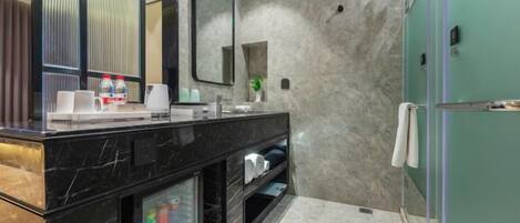 Un baño moderno con tocador de mármol, un espejo grande y cabina de ducha de cristal.