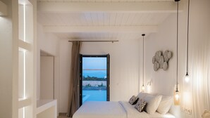 Ein Schlafzimmer mit einem großen Bett, Meerblick und einem Balkon.