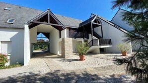 Uma casa moderna de dois andares com entrada coberta e varanda.