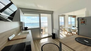 Eine moderne Küche mit Meerblick, ein Essbereich mit Tisch und Stühlen und eine kleine Sitzecke mit Aussicht.