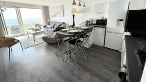 Eine moderne Wohnung mit Essbereich, Küche und einem Balkon mit Blick.