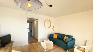 Ett modernt vardagsrum med en soffa, en tv och en matplats.