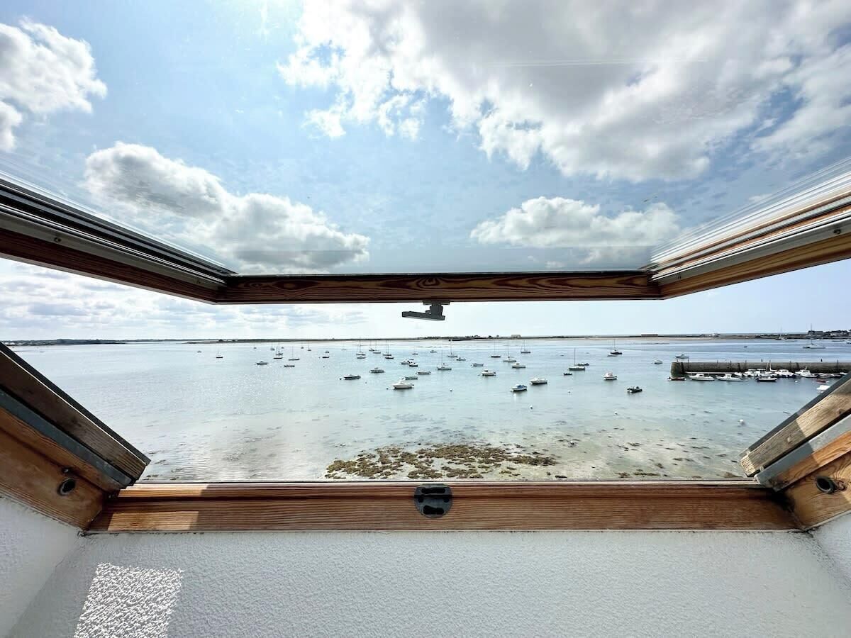 Blick vom Bootsdeck mit Holzwand auf ruhiges Wasser, auf dem sich mehrere Boote befinden.