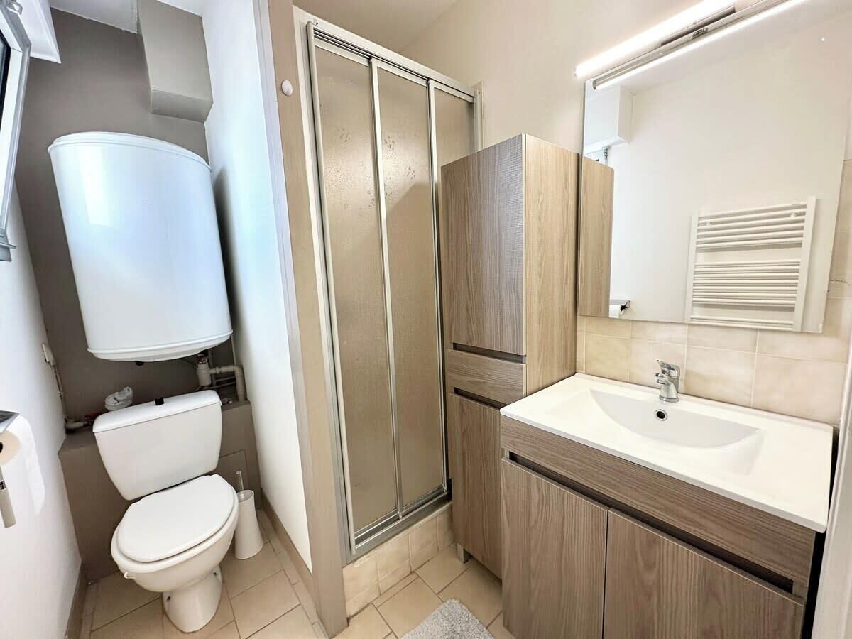 A modern bathroom with a toilet, shower, and sink.