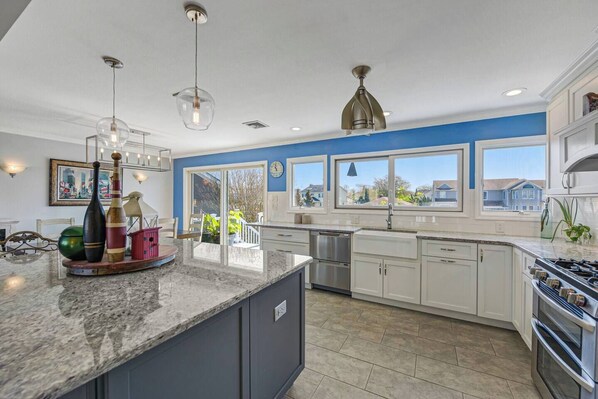 A modern kitchen with a large island, stainless steel appliances, and a view of the neighborhood. - Waterfront Escape in Long Island NY (massapequa)