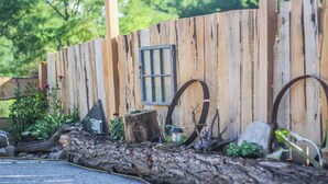 A rustic wooden fence with a window and decorative metal rings. - Magic Forest Farm's Mountain View Suite (Coeymans Hollow)