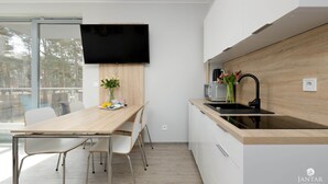 Eine moderne Küche mit Holzarbeitsplatte, integriertem Spülbecken und einem flachbildfernseher an der Wand.