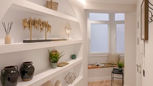 Un couloir moderne avec des étagères blanches, un plancher en bois et une fenêtre offrant une belle vue.