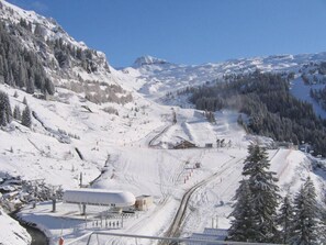 Ein verschneites Skigebiet mit Sessellift, Skipisten und einer Lodge namens "Télésiège des Grands Vans".