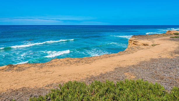 Eine Küstenlandschaft mit Sandstrand und Wellen.