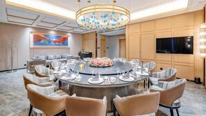 A modern dining area with a round table set for a meal, surrounded by chairs.