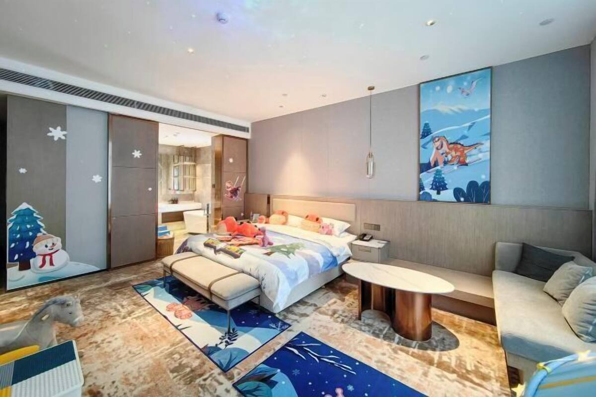 A modern bedroom with a bed, bedside table, and a sofa.