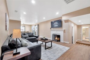 Una Smart TV, una chimenea, libros, una pantalla de ordenador