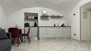 A compact living space with a dining area, kitchenette, and a sofa. - Andrea's Place - cozy apartment 5 minutes from the Archaeological Museum (Napoli)