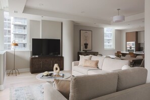 A modern living room with a sofa, coffee table, and a flat-screen TV.