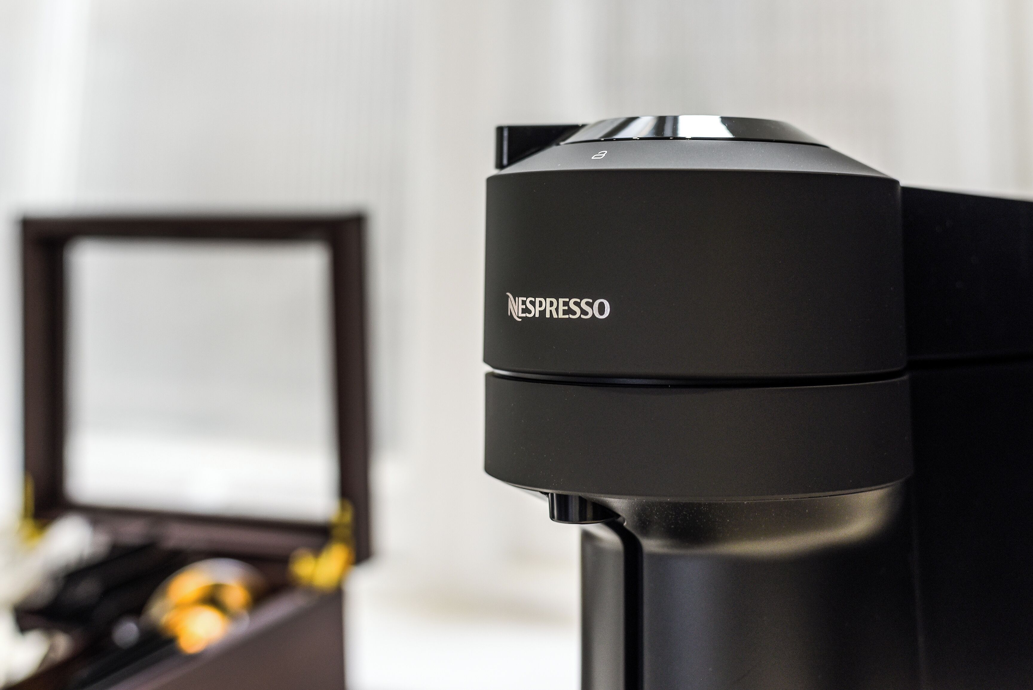 A Nespresso coffee machine with a sleek black design, a coffee pod holder, and a coffee maker.