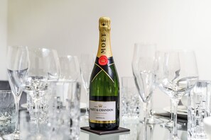 A bottle of Moët & Chandon champagne on a table surrounded by empty wine glasses.