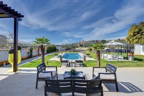 A patio with outdoor furniture, a swimming pool, and a view of the neighborhood. - Beachfront Villa Contessa Del Mar (Pješčana Uvala)