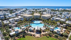 Ein Resort mit mehreren Gebäuden, einem zentralen Pool und Meerblick.