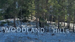 A snowy landscape with a sign reading "WOODLAND HILLS". - Charming luxury studio cottages with hints of rustic flare to help you RECHARGE (Woodville)