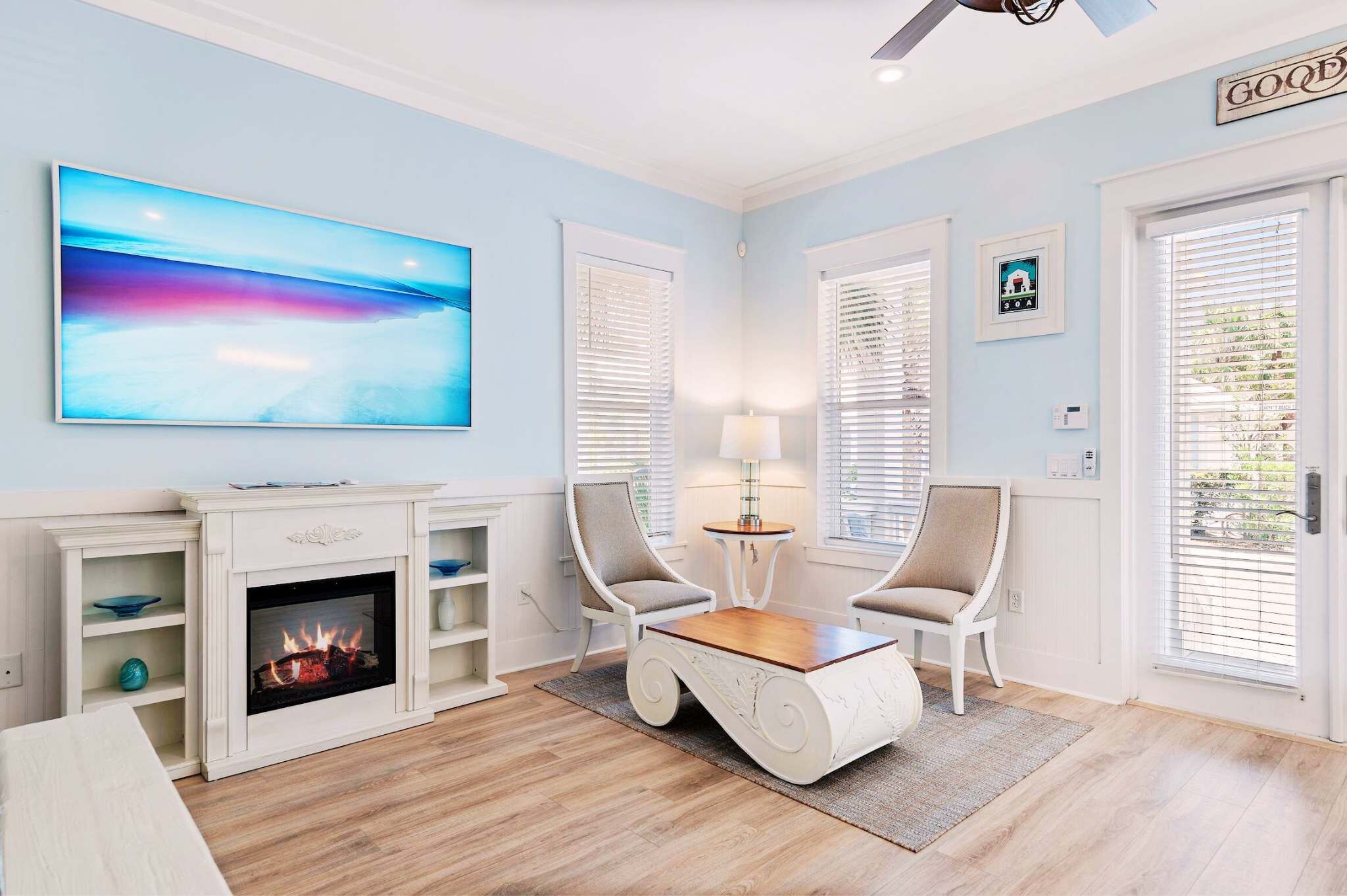 Una sala de estar con chimenea, un televisor y dos sillones.