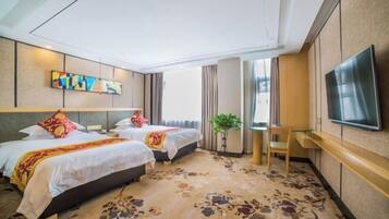 A hotel room with two beds, a flat-screen TV, a small desk, and a large window.