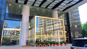 Un bâtiment moderne doté de grandes fenêtres en verre et d’un espace d’entrée abrité.