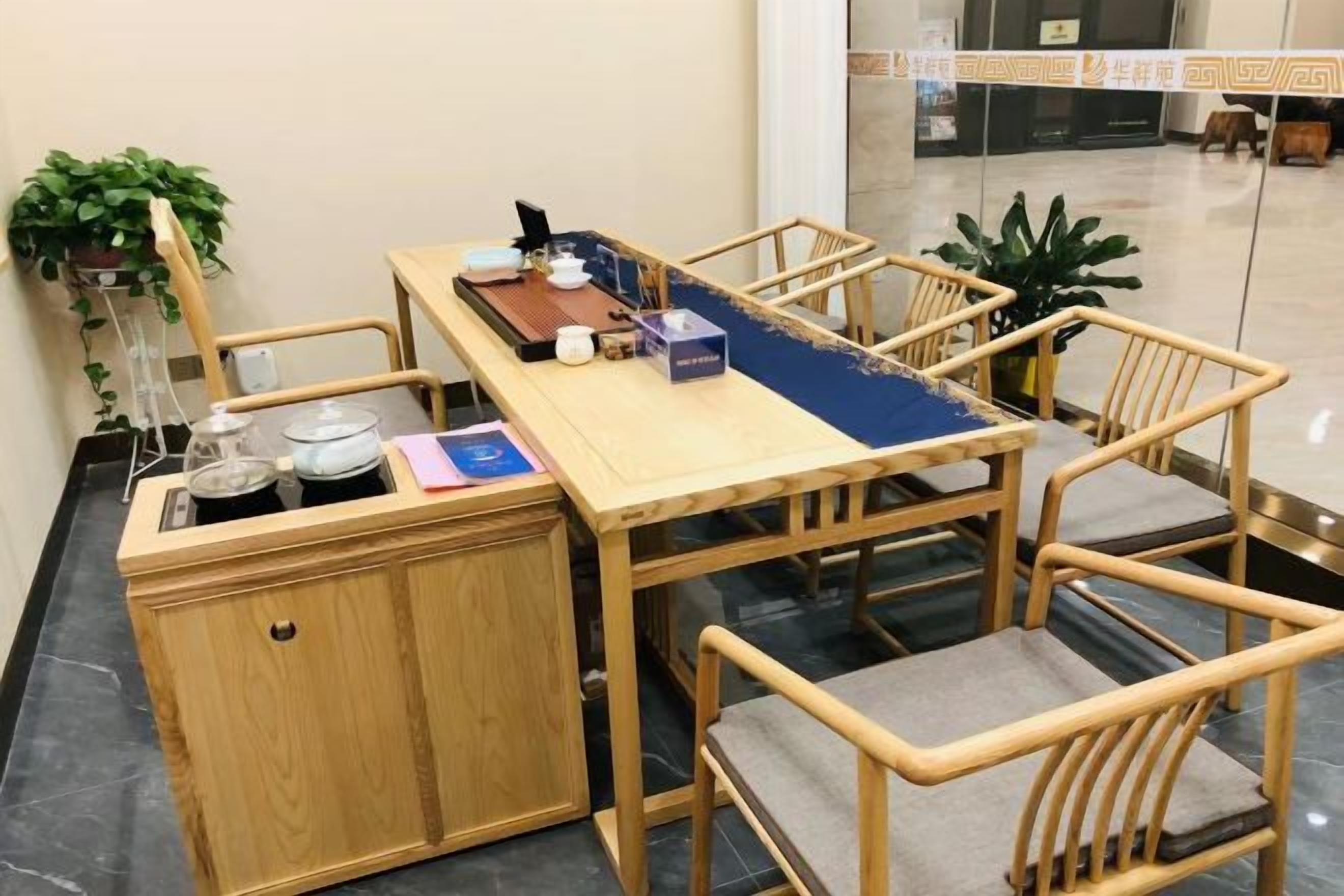 A wooden dining table with chairs, a small cabinet, and a blue table runner.
