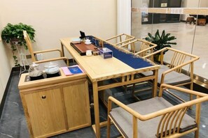 A wooden dining table with chairs, a small cabinet, and a blue table runner.