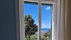 A white-framed door with a view of a tree and a distant landscape. - Villa Esmeralda (Salerno)