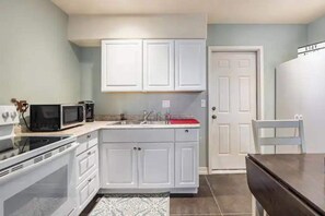 Een magnetron, een oven, een kookplaat, kookgerei, borden en bestek