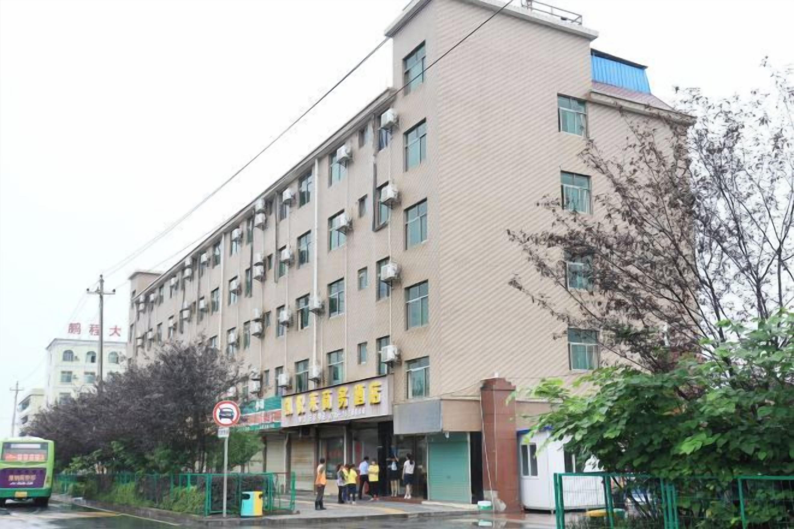 Un edificio de varios pisos con un letrero que indica un comercio o establecimiento de servicios en la planta baja.