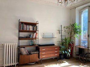Cozy retreat with a vintage flair, featuring a bookshelf, desk, and potted plant.