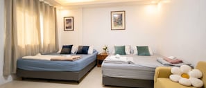 A hotel room with two beds, a nightstand, and a chair.