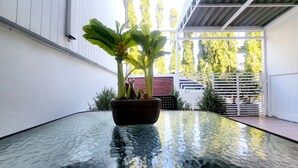 Une table dont le plateau est en verre, avec une plante en pot placée au centre.