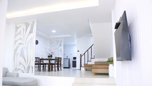Un salon moderne comprenant un canapé, une table basse et un coin repas avec des chaises et une table.