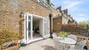 A brick exterior with a white door leading to an interior space. - Exceptional 2 bed, 2 bath, South Ken Apt (London)