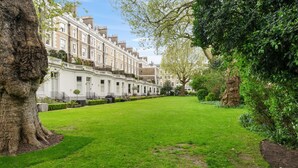 A row of terraced houses with a well-maintained lawn in the foreground. - Exceptional 2 bed, 2 bath, South Ken Apt (London)