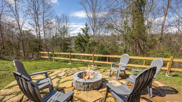 An outdoor seating area with Adirondack chairs and a fire pit. - Recreational Playing One On One (SEVIERVILLE)