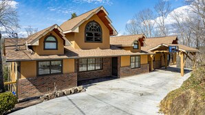 A two-story house with a brick facade, large windows, and a sloped roof. - Recreational Playing One On One (SEVIERVILLE)