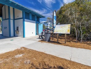 A building with a blue and white exterior, a bench, and a signboard.