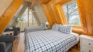 A cozy loft bedroom with a large bed, a desk, and a TV. - Your Family Reunion Getaway (GATLINBURG)