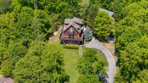 An aerial view of a cabin surrounded by dense forest, with a visible driveway leading to the entrance. - Gated Resort*Complimentary Wifi*Mtn. Views*Seasonal Pool (SEVIERVILLE)