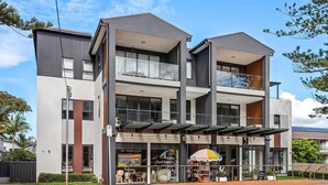 A modern two-story building with a ground-level shop and upper residential units.