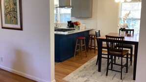 Une cuisine moderne avec un îlot central, des chaises en bois et une table à manger.