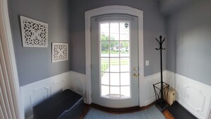 A corner hallway with a white door, a bench, and two decorative wall panels. - Spacious, Fully-Stocked, Walking distance to Downtown - With Comfy Mattresses! (Bardstown)