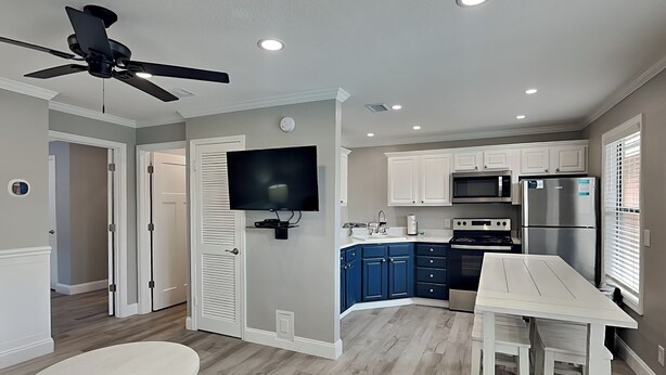 A modern kitchen with white cabinets, a built-in oven, and a stainless steel refrigerator. - Paradise Isle #15A by Southern Vacation Rentals (Gulf Shores)