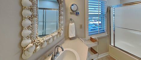 A bathroom with a large mirror, sink, and toilet.